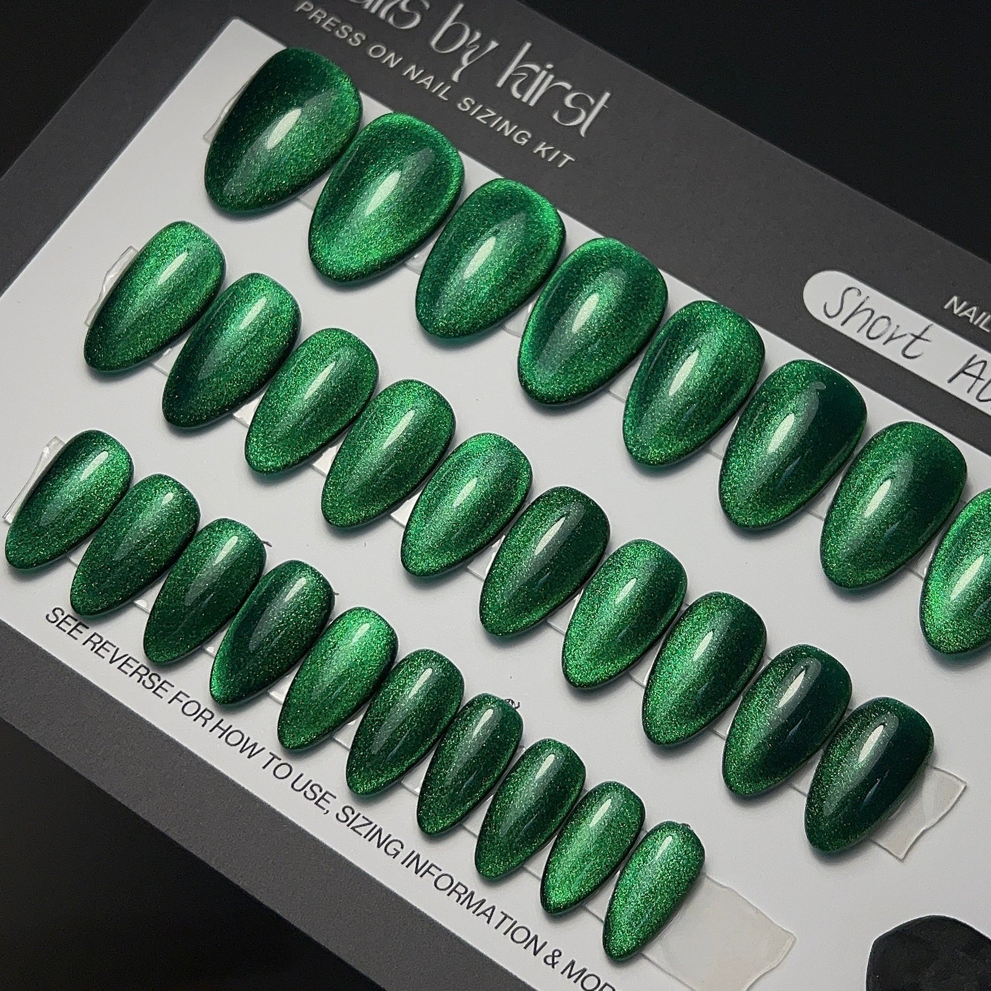 Set of green glittery press-on nails on a sizing kit