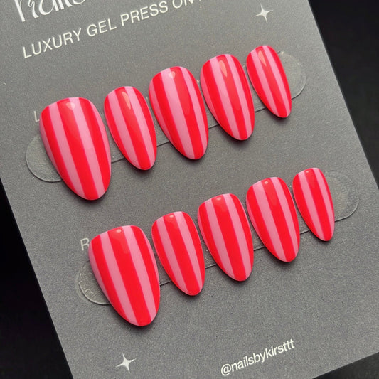 Red gel press on nails on a gray card with 'nails by kirst' branding