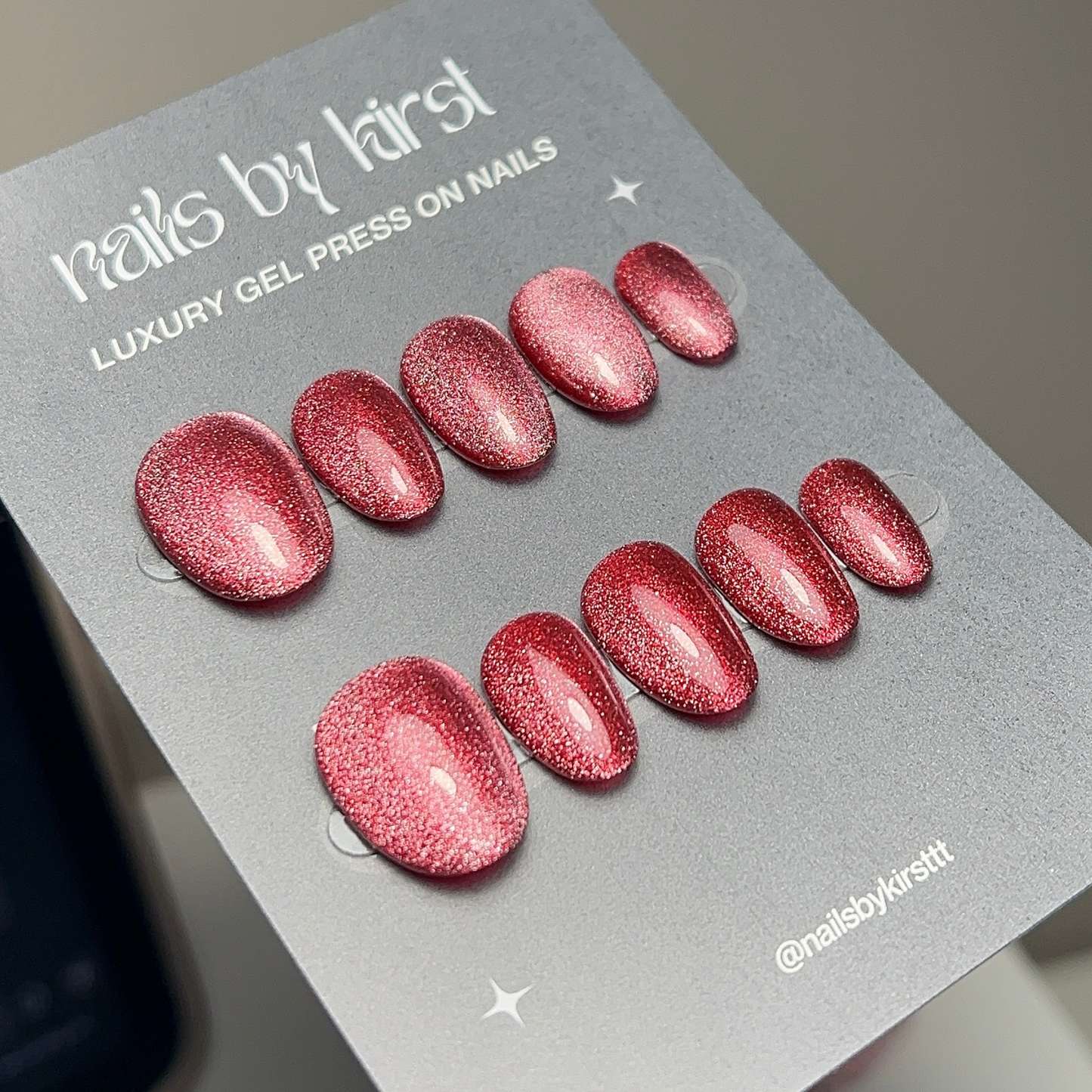 red cat eye press on nails on a grey backing card with the text "luxury gel press on nails"