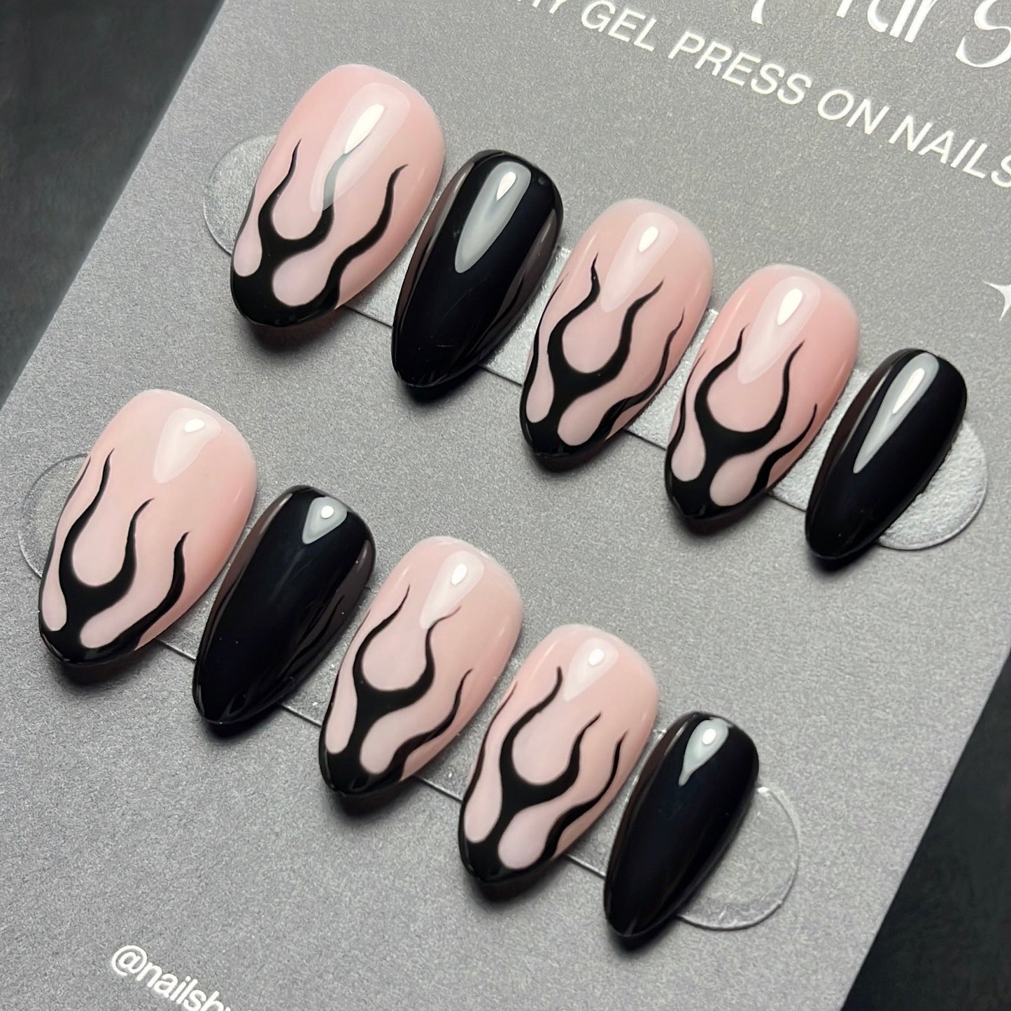 Set of press-on nails with black and pink flame design on a 'nails by kirst' branded card.