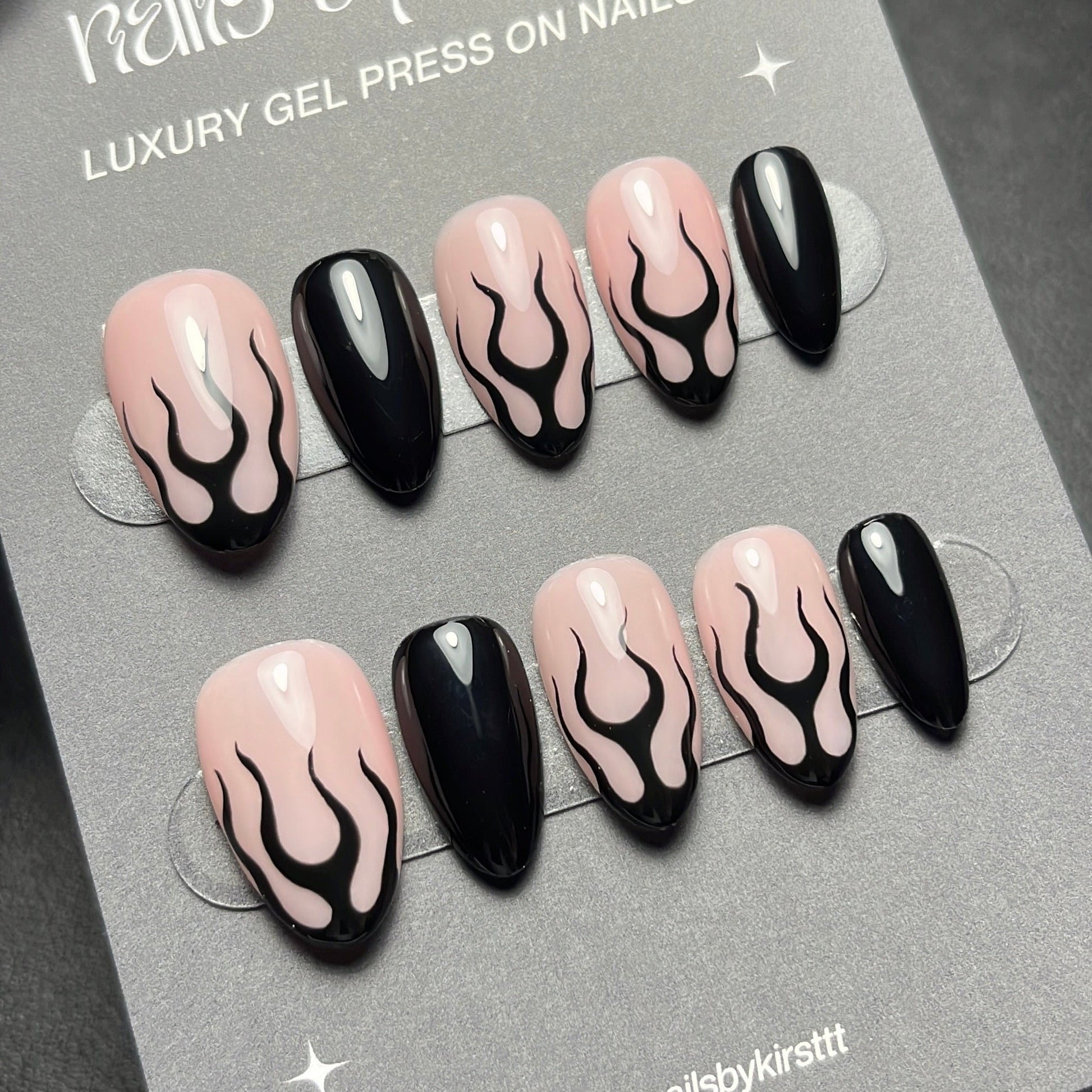 Set of press-on nails with black  flame design on a gray card with 'nails by kirst' branding.