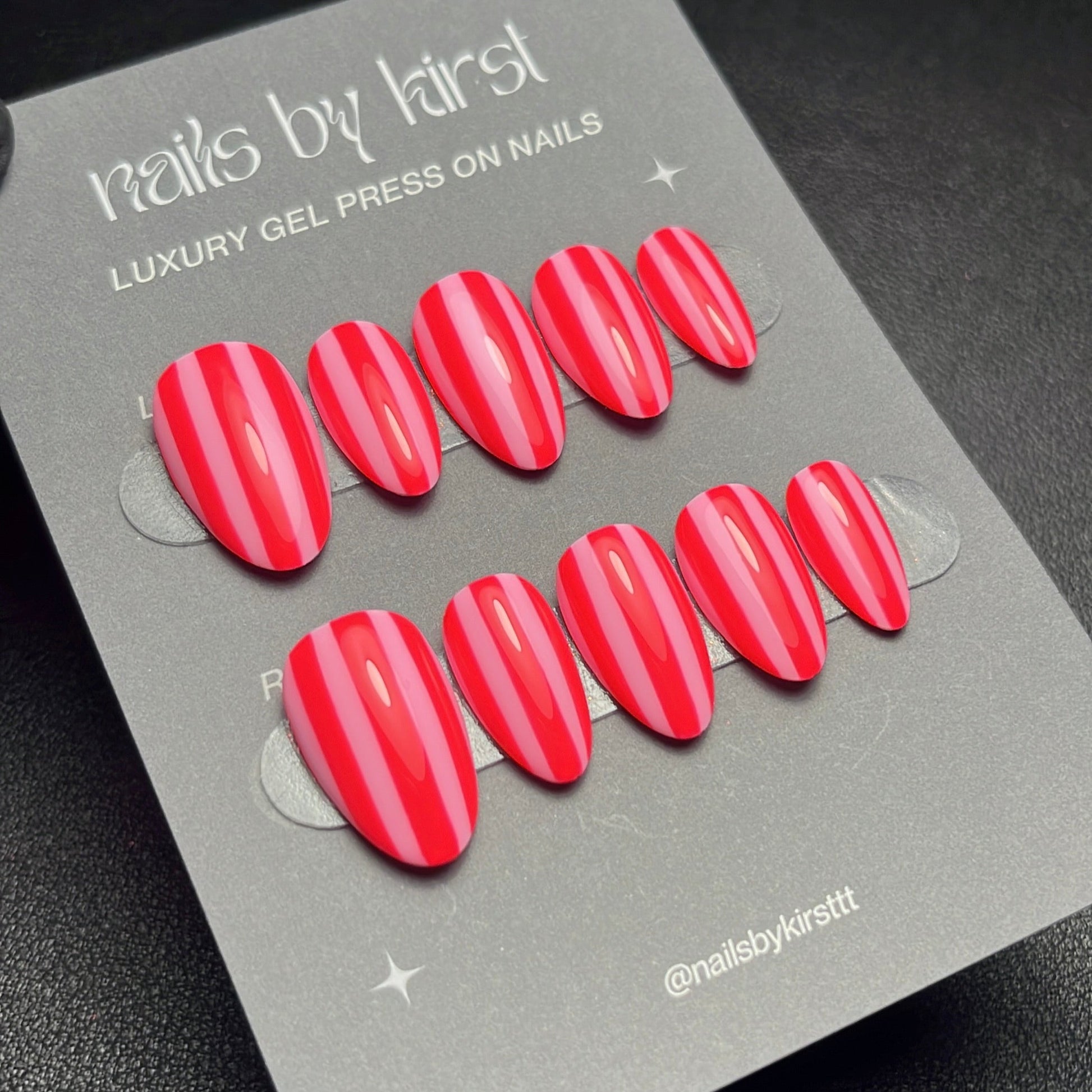 Packaging of red gel press on nails with 'nails by kirst' branding on a dark background.