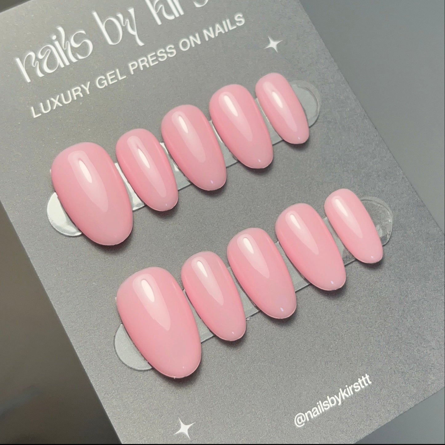 sheer pink press-on nails on a grey card with 'nails by kirsttt' branding.